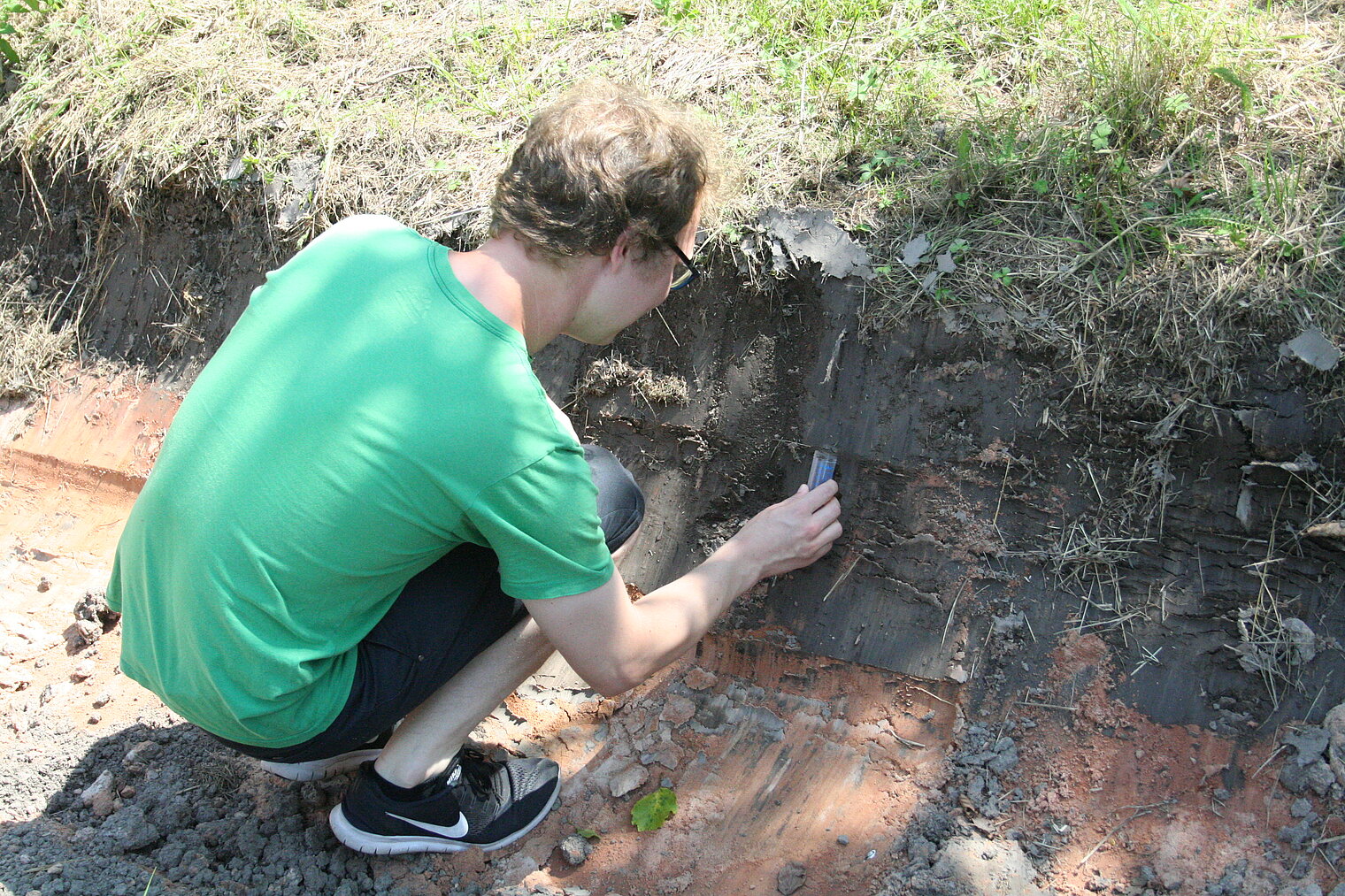 Masterstudent Julian Thimm entnimmt eine Bodenprobe