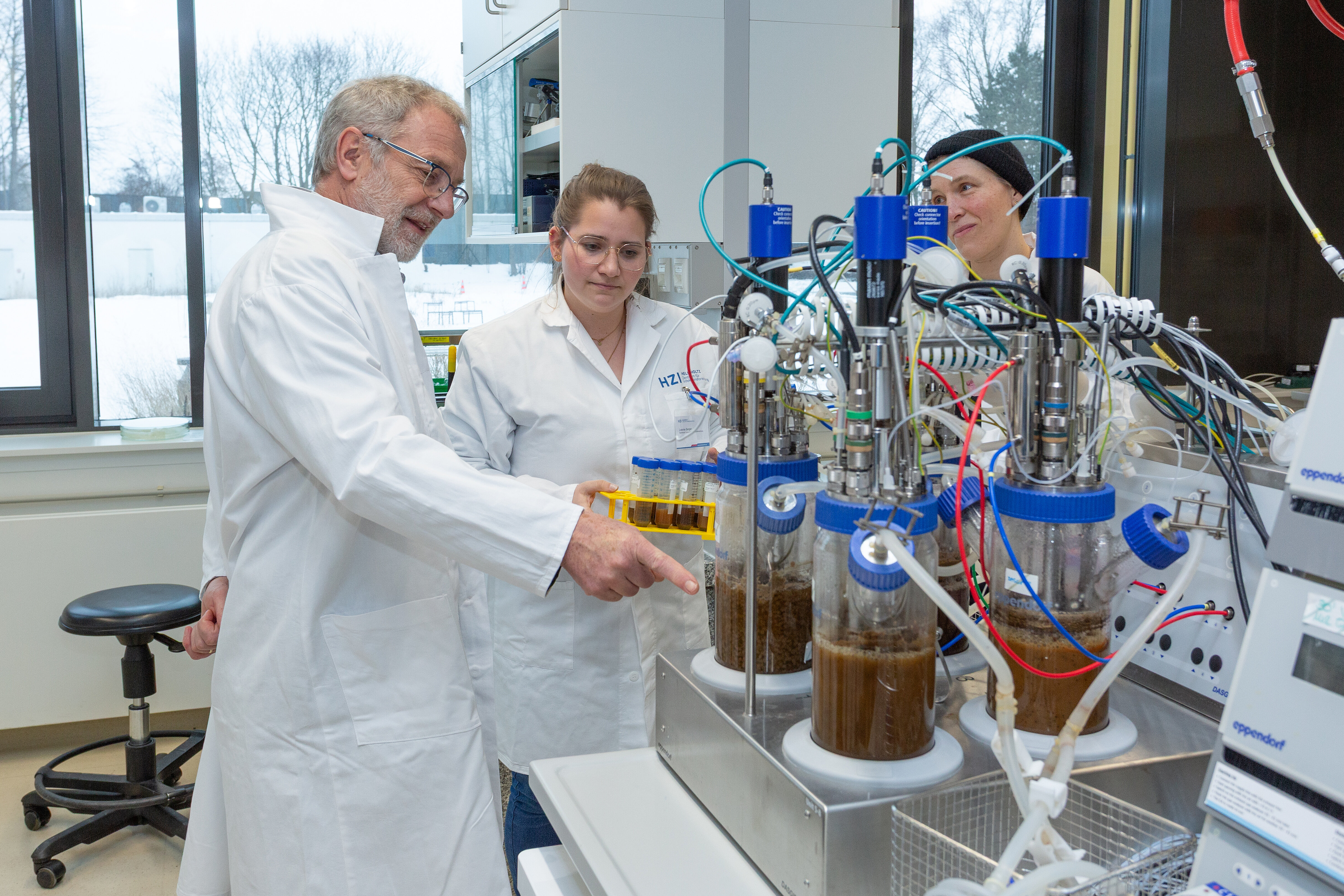 Two people in lab coats talking in front of a laboratory device