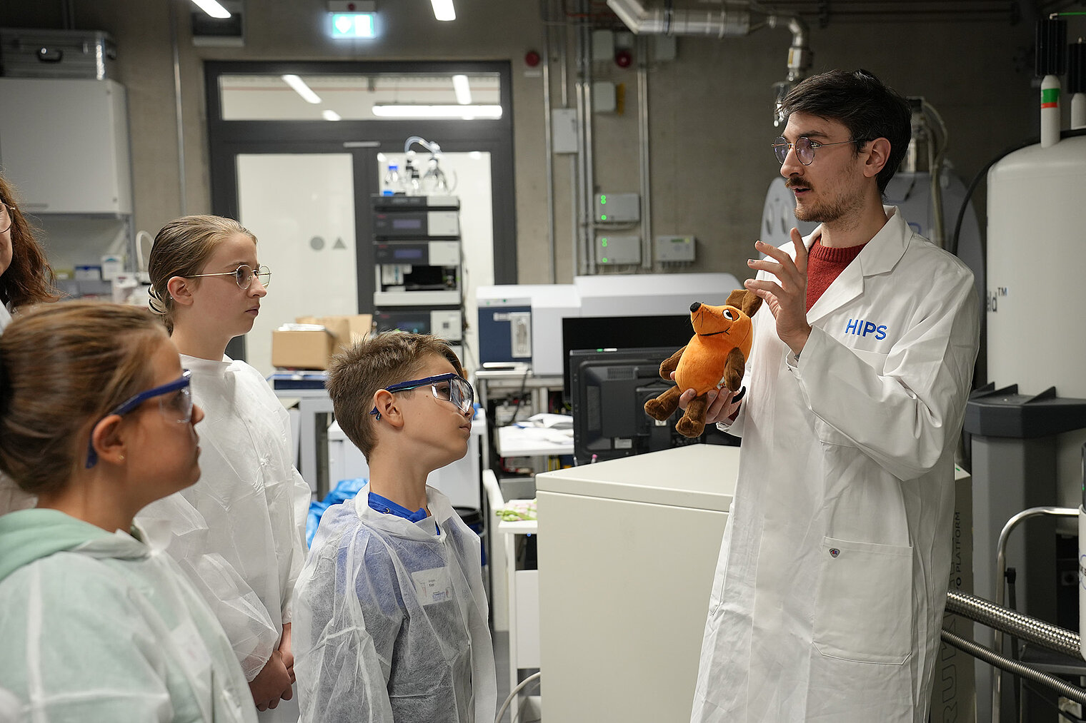 Ein Wissenschaftler mit einer Plüschmaus im Labor