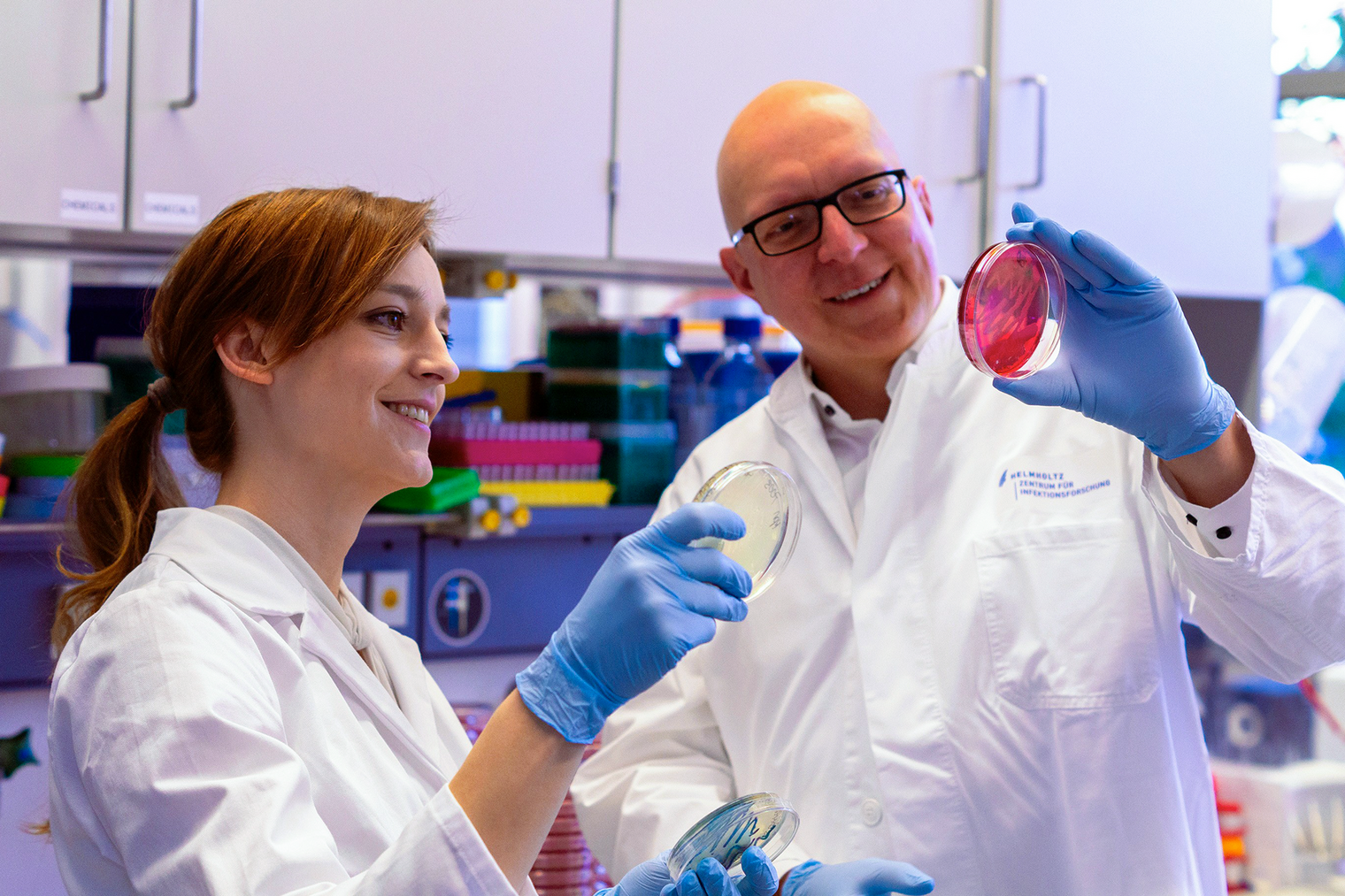Two researchers examine a Petri dish in the laboratory.