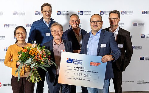 Group picture of 6 people with an oversized cheque