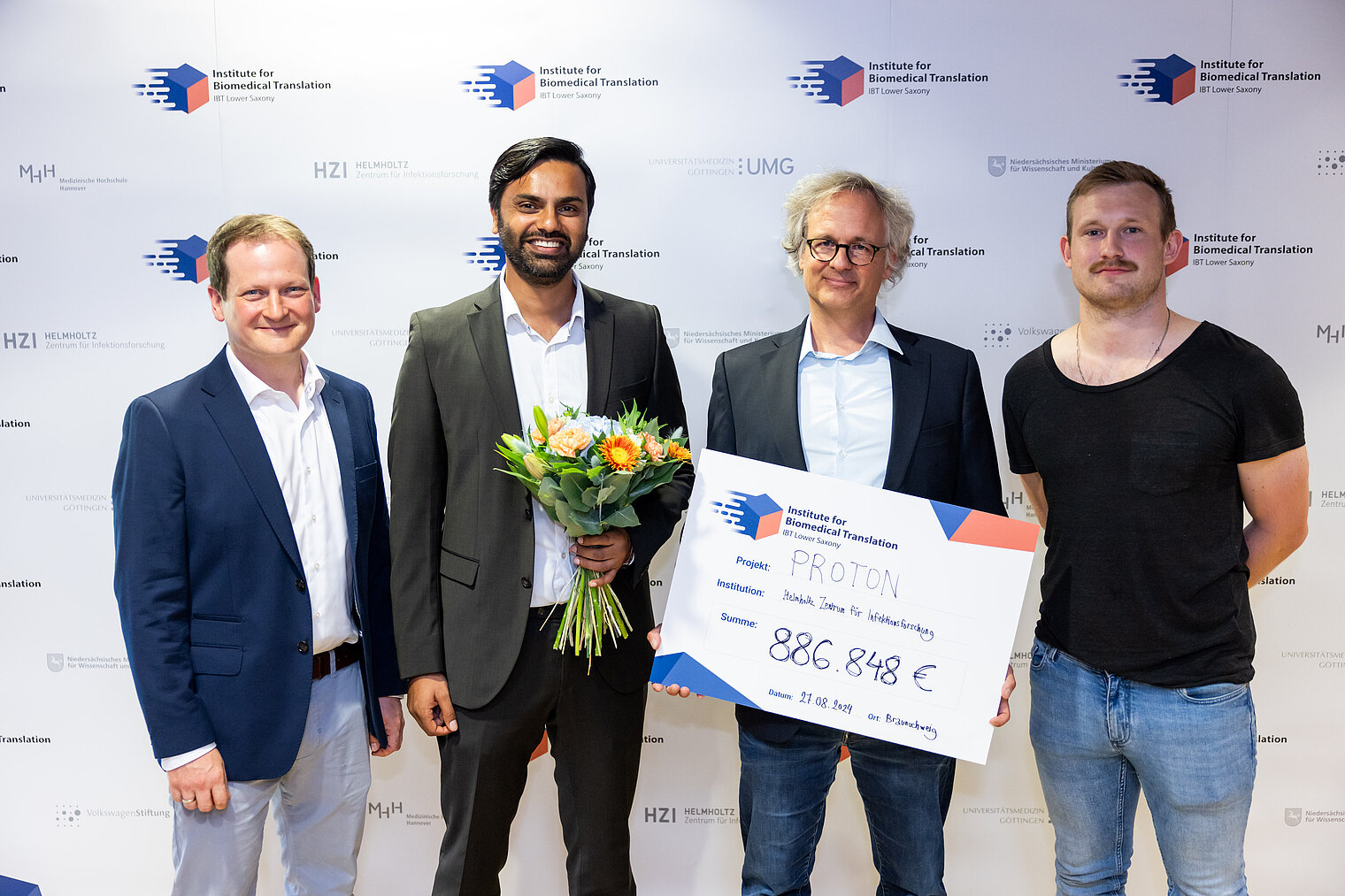 Group photo 4 scientists with a large cheque