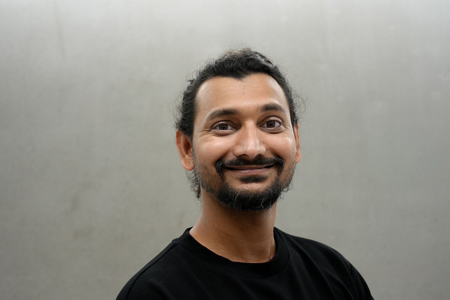 Portrait von Jiteshkumar Deore vor einer grauen Wand