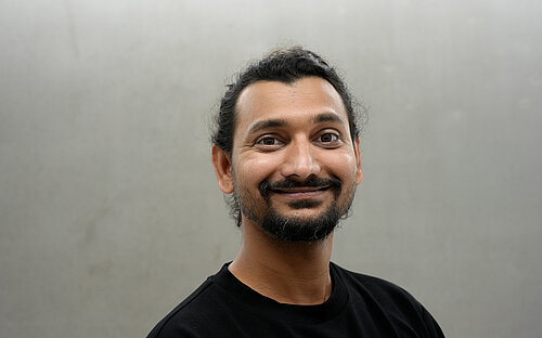 Portrait of Jiteshkumar Deore in front of a gray wall