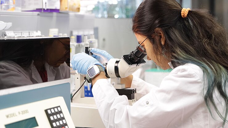 Sampurna Chakrabarti polishing a glass pipette looking through a microscope