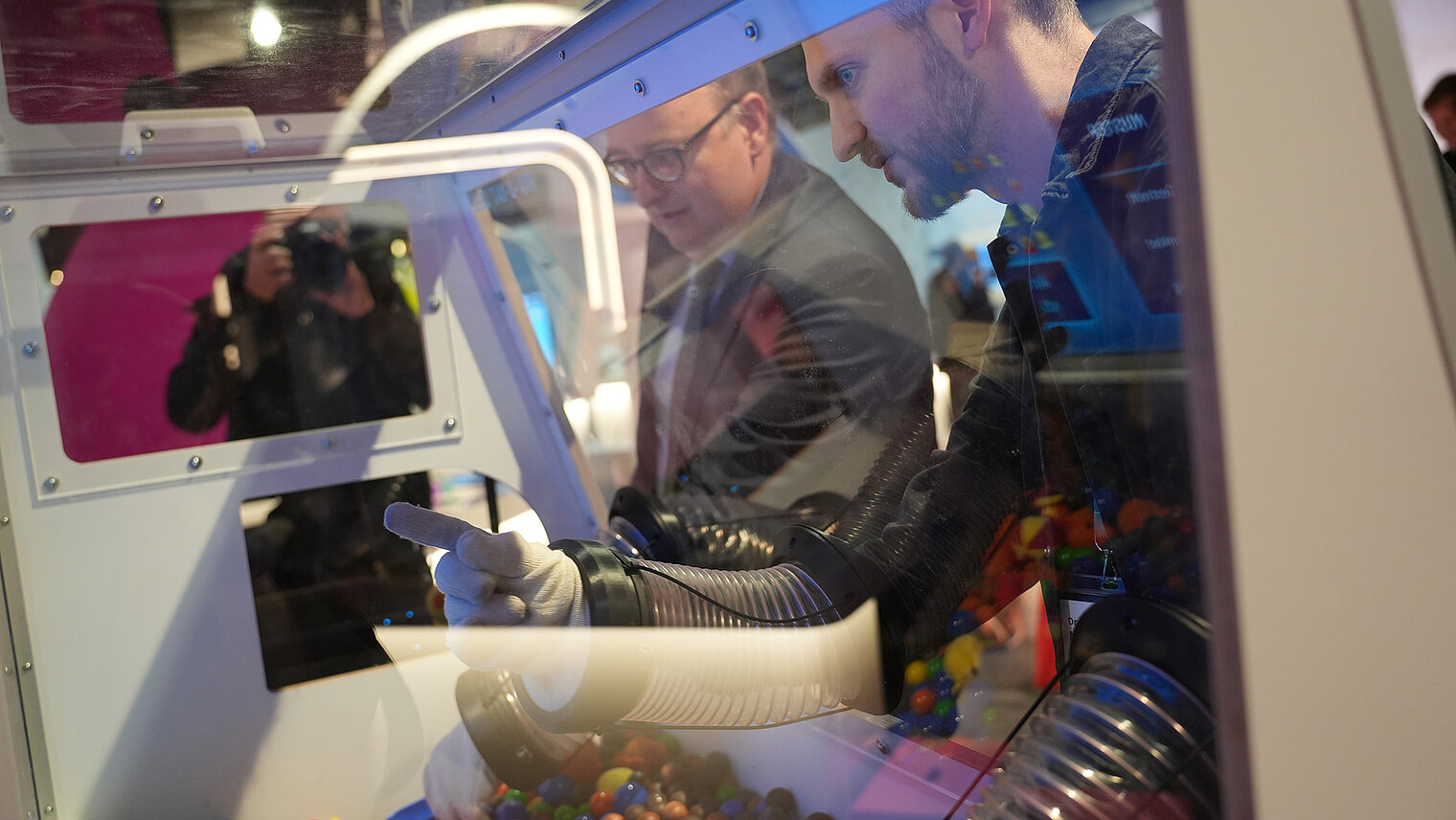 Two people are looking at the MYXO-MAT-3000 and peering through a window