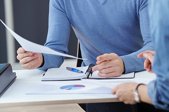 People in an office conversation with documents