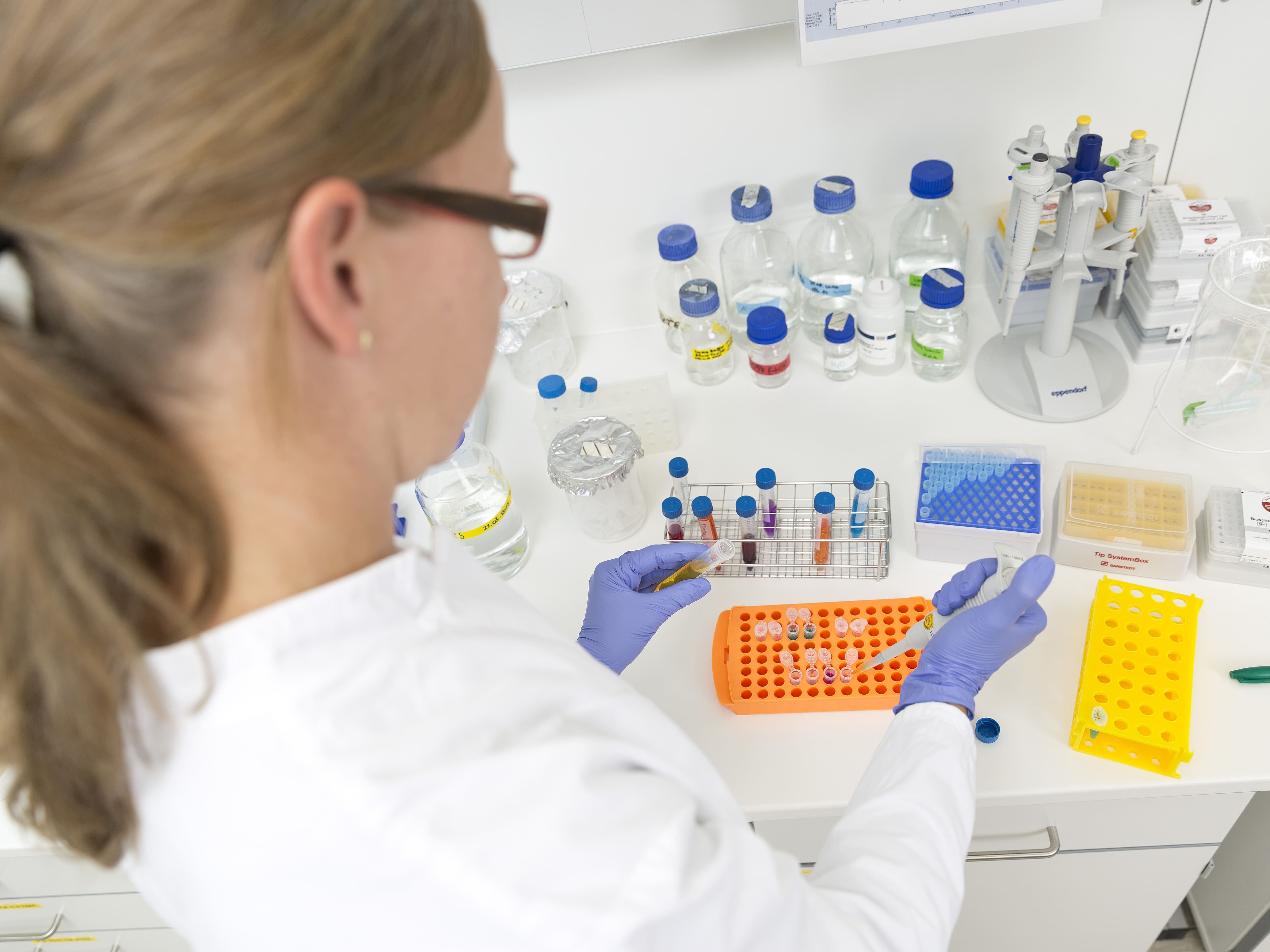 Wissenschaftlerin pipettiert in Eppendorf Tubes.