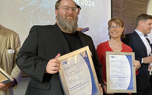 Jan Böhme und Stefanie Castell halten gerahmte Urkunden