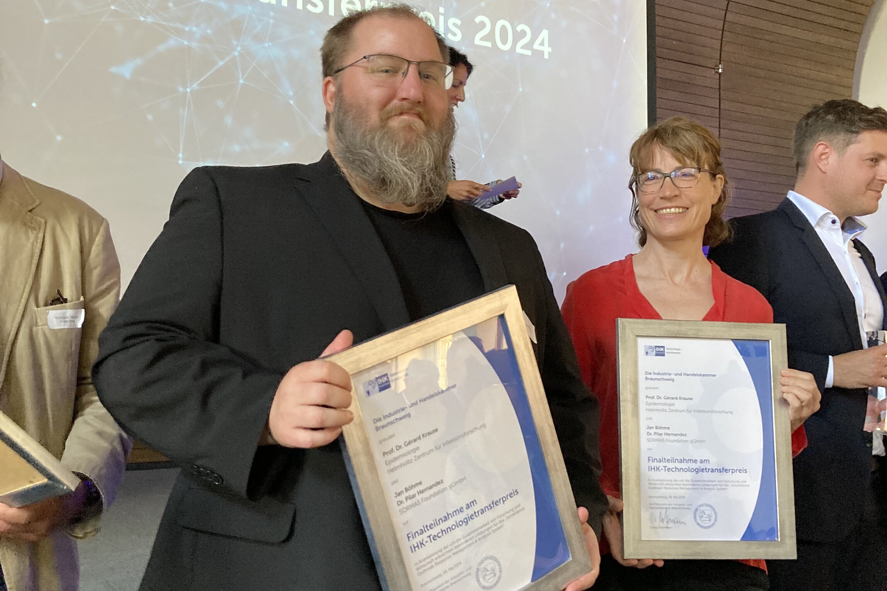 Jan Böhme und Stefanie Castell halten gerahmte Urkunden