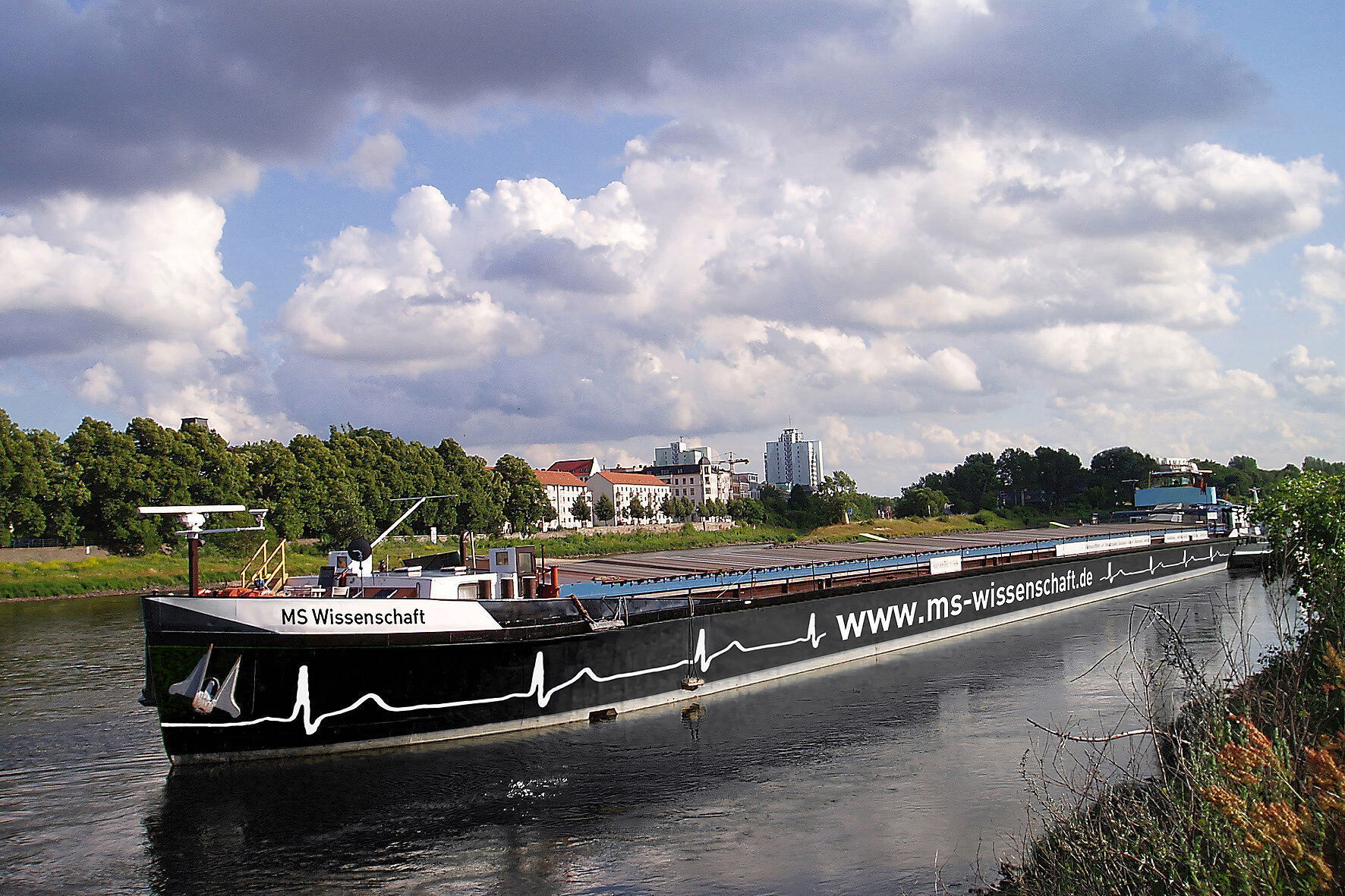 Ein großes Frachtschiff mit dem Aufdruck "MS Wissenschaft" auf einem Fluss