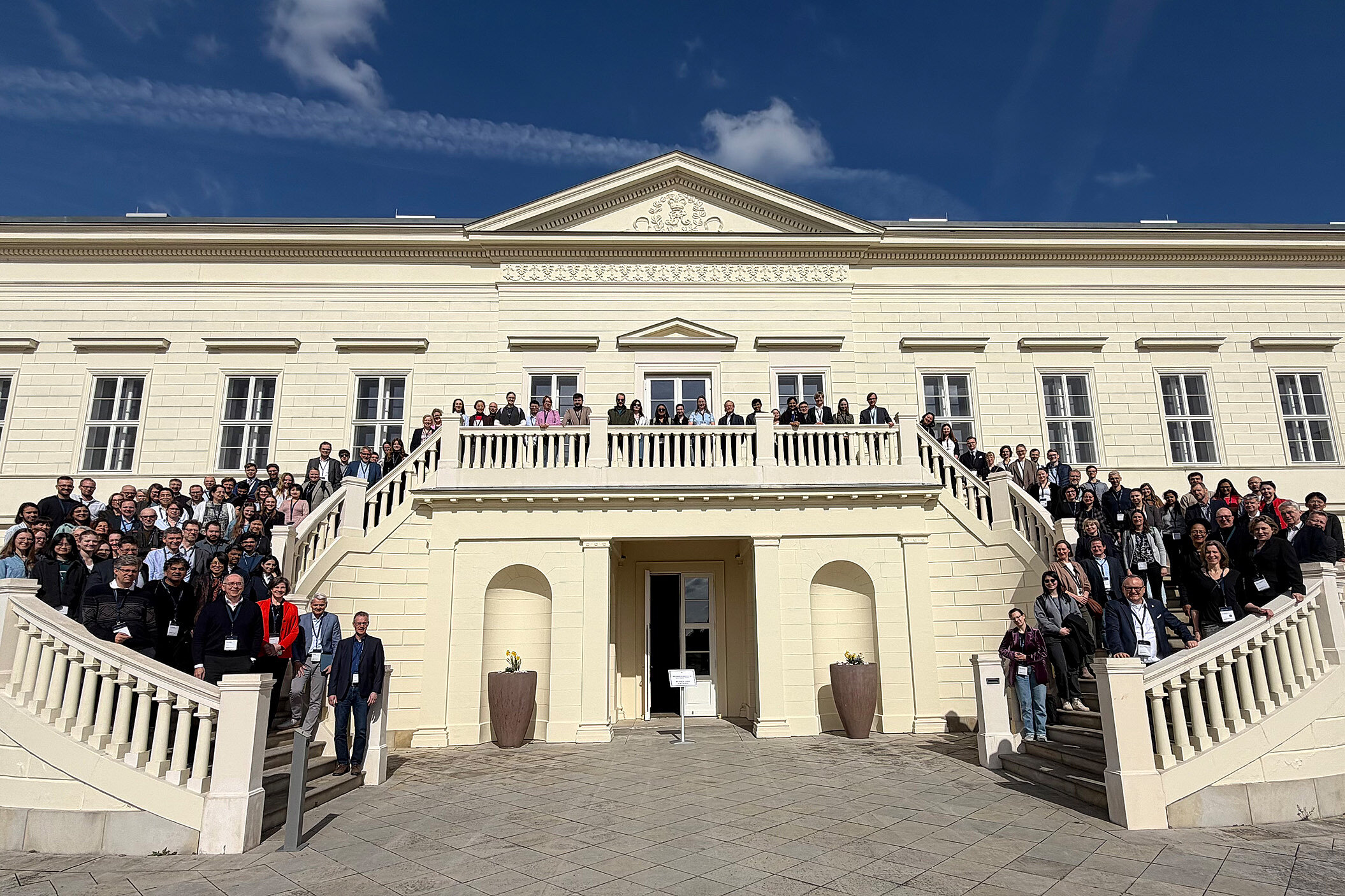 Gruppenfoto mit etwa 100 Personen auf Treppen vor einem Hauseingang