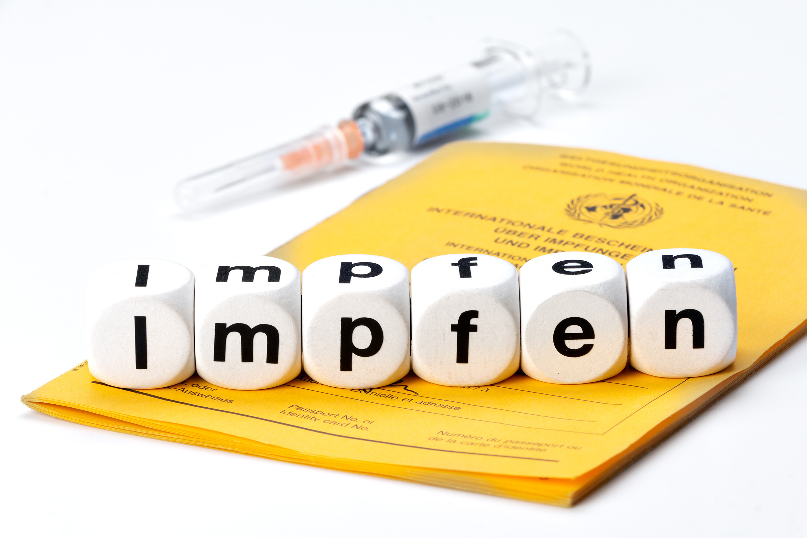  The word “impfen” (German word for vaccines) spelled out using dice with individual letters, arranged on a vaccination certificate